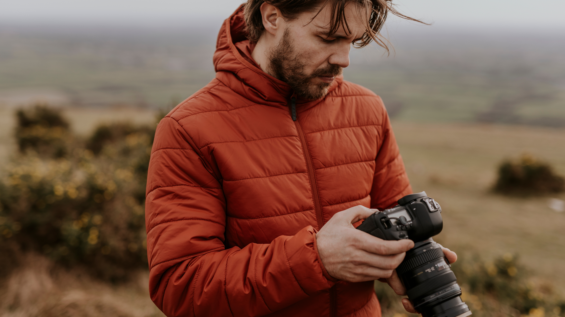 Image of a photographer looking at the back of their camera on a shoot