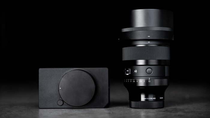 Sigma 85mm f/1.2 DG Art lens and compact camera body on display